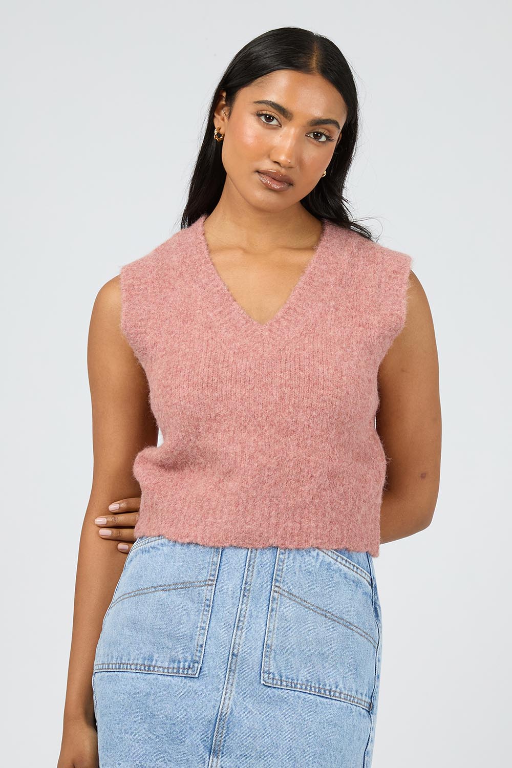 A model wearing the Leah Knit Vest in colour Quartz (Pink), from the front, cropped image