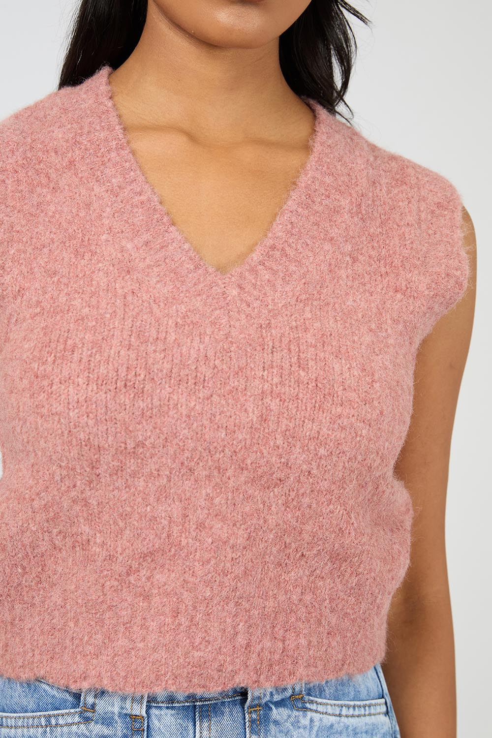 A model wearing the Leah Knit Vest in colour Quartz (Pink), from the front, cropped image