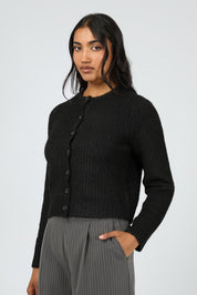 A model wearing the Aya Cardigan in colour Black (Black), from the front, cropped image