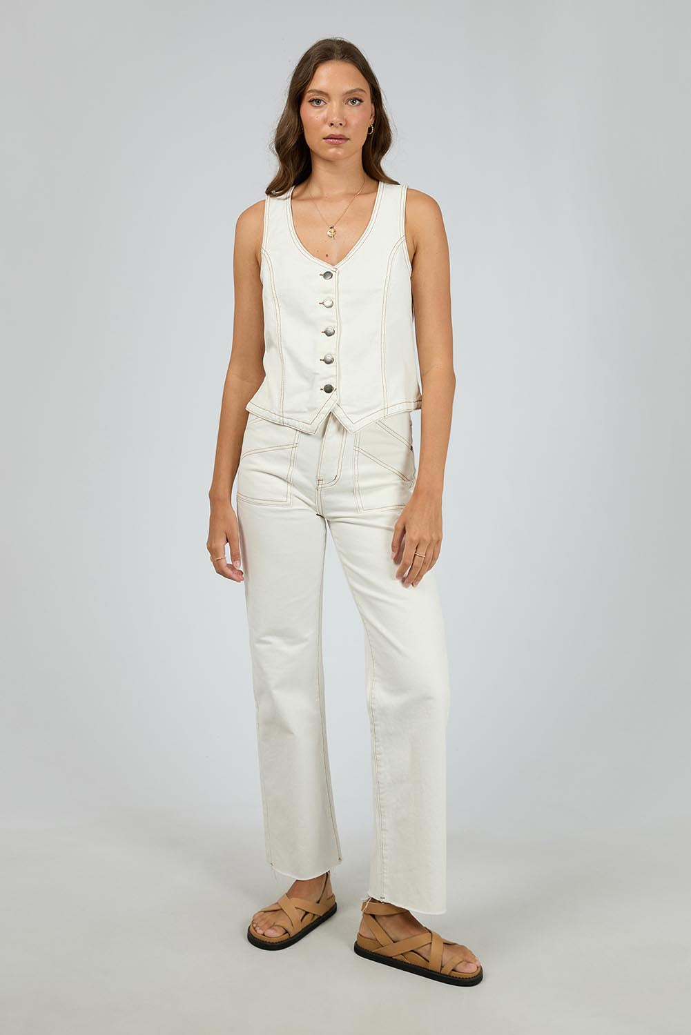 A model wearing the Korin Denim Vest in colour Vwhite (White), from the front, showing the whole outfit