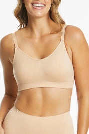 A model wearing the Bare Essentials Support Wirefree Bra in colour Beige, from the front, cropped image