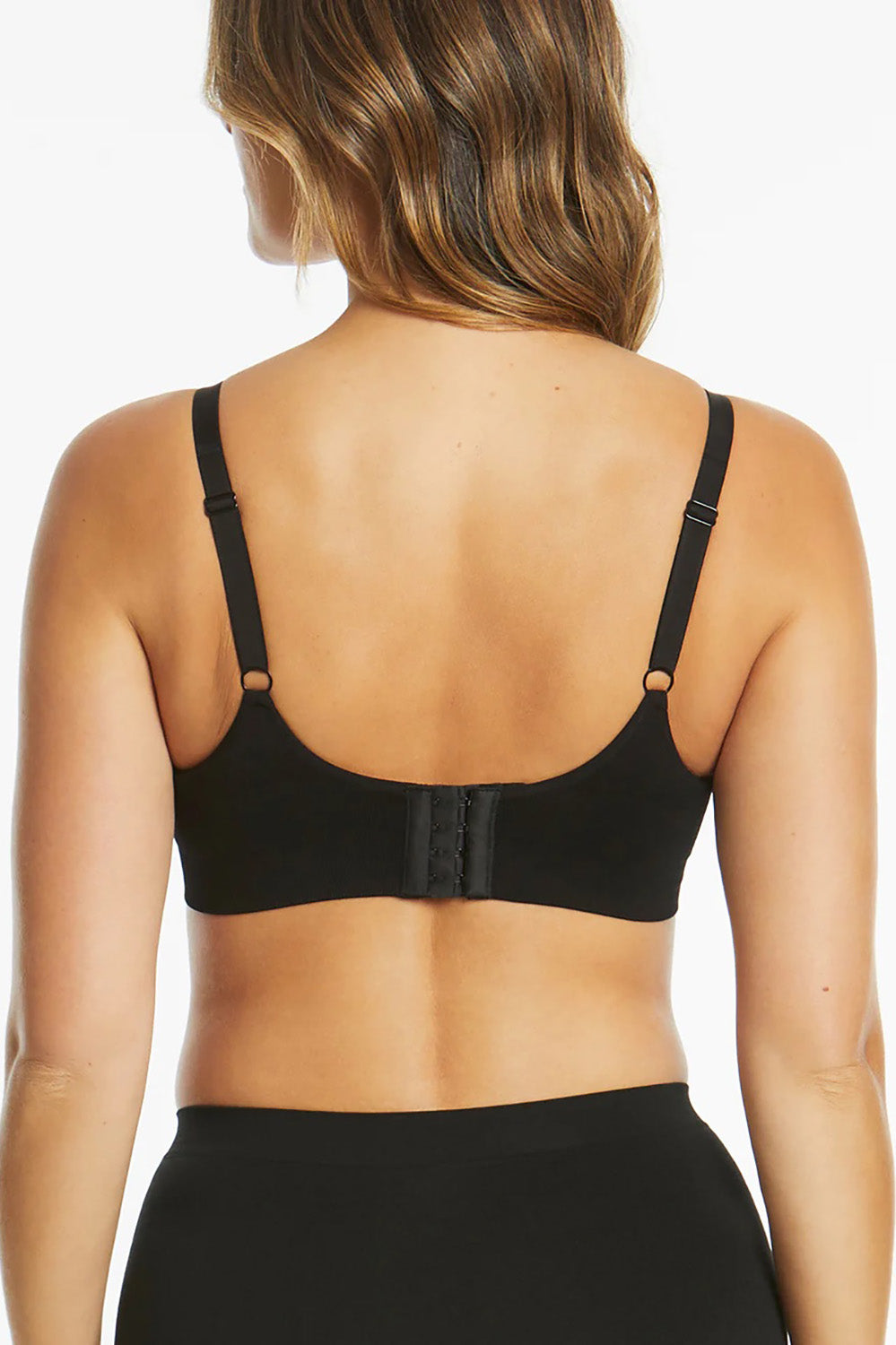 A model wearing the Bare Essentials Support Wirefree Bra in colour Black, from the back