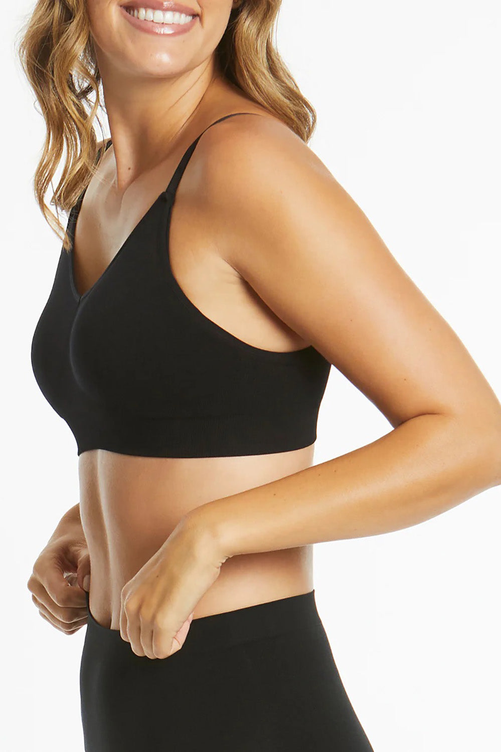 A model wearing the Bare Essentials Support Wirefree Bra in colour Black, from the front, cropped image