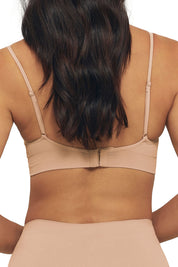 A model wearing the Bare Essentials Padded Wirefree Bra in colour Rosebeige, from the back