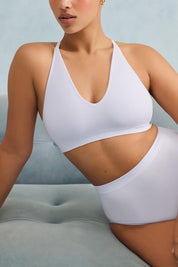 A model wearing the Pure Basics Triangle Modal Bralette in colour Aurablue (Blue), from the front, cropped image