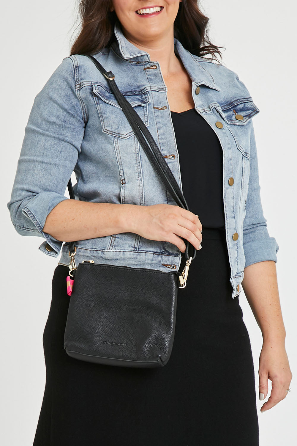 Model Tahlecia wearing size OneSize of the Alexis Leather Crossbody in colour Black (Black), from the front, cropped image
