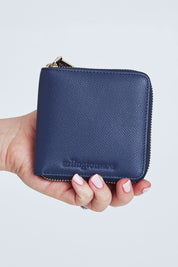 A model wearing size OneSize of the Zoe Leather Wallet in colour Navy (Blue), from the front, cropped image