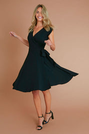 Model Alice wearing size S of the Wrap Dress in colour Black (Black), from the front, showing the whole outfit