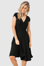 A model wearing the Wrap Dress in colour Black (Black), from the front, cropped image