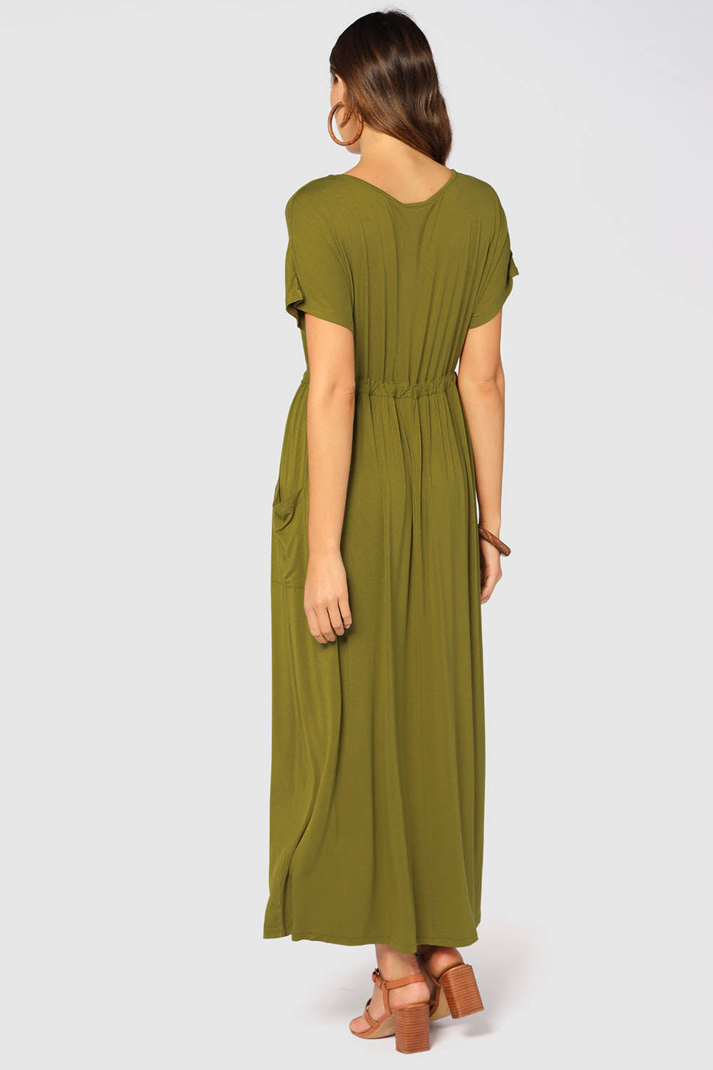 A model wearing the Mila Maxi Dress in colour Cardamom (Green), from the back