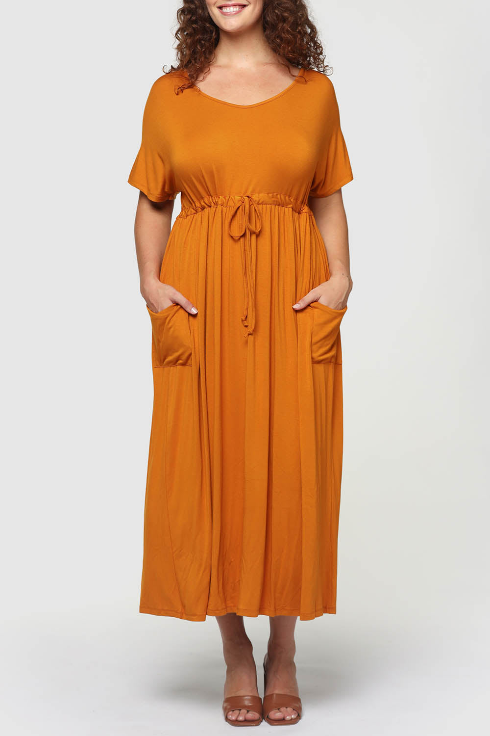 A model wearing the Mila Maxi Dress in colour Tumeric, from the front, cropped image