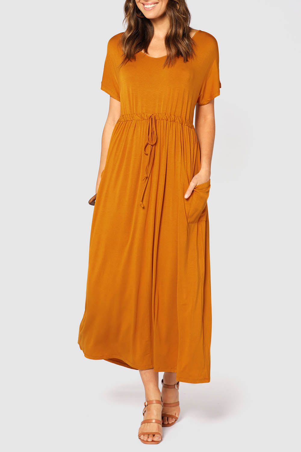 A model wearing the Mila Maxi Dress in colour Tumeric, from the front, cropped image