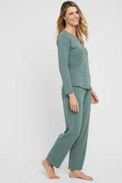A model wearing the Henley Long Sleeve Bamboo Top in colour Moss (Green), from the front, showing the whole outfit