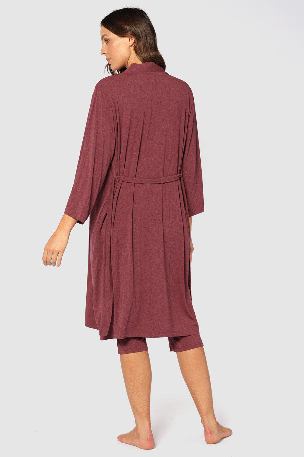 A model wearing the Bamboo Robe in colour Burgundy (Red), from the back
