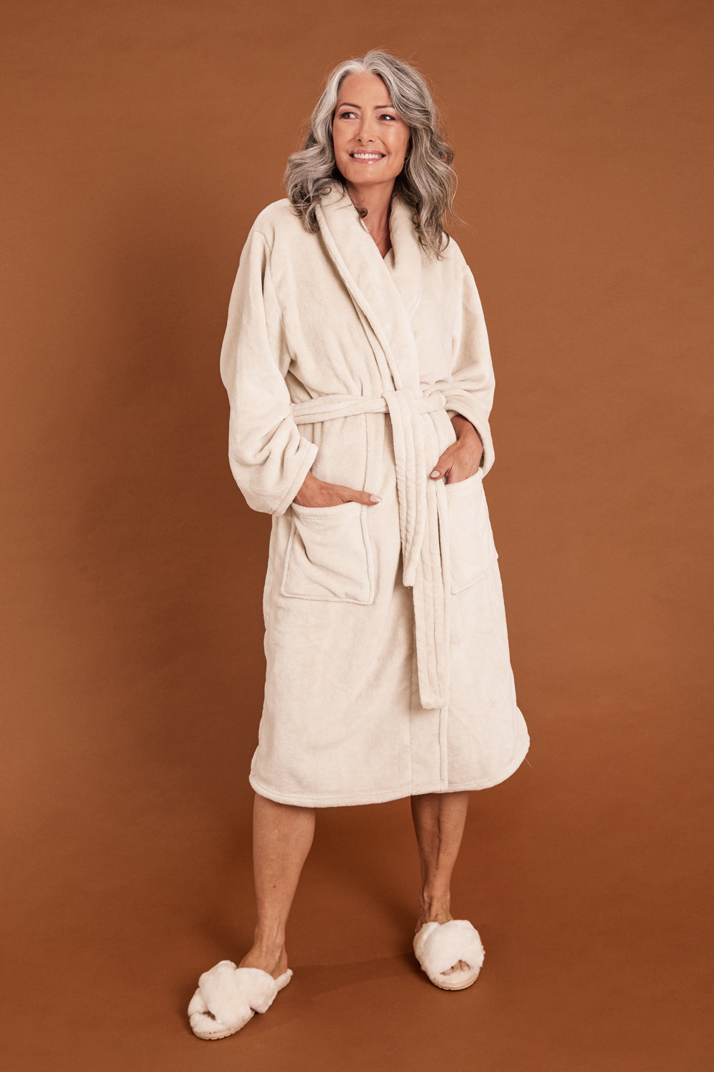 Model Luisa wearing the Microplush Bath Robe in colour Stone, from the front, showing the whole outfit