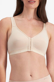 A model wearing the Post Surgery Front Opening Bra in colour Bodytone, from the front, cropped image