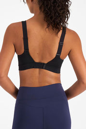 A model wearing the Smooth Power Wirefree Sports Bra in colour Black (Black), from the back