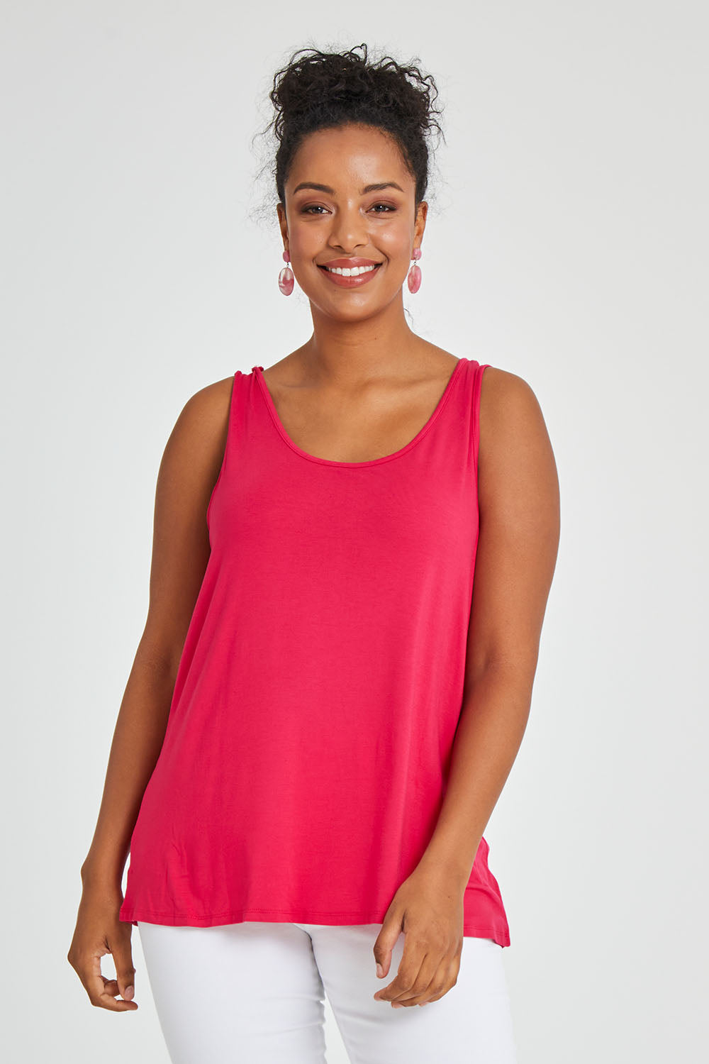 Model Noli wearing size 14 of the Sirena Reversible Tank in colour Rosered (Red), from the front, cropped image
