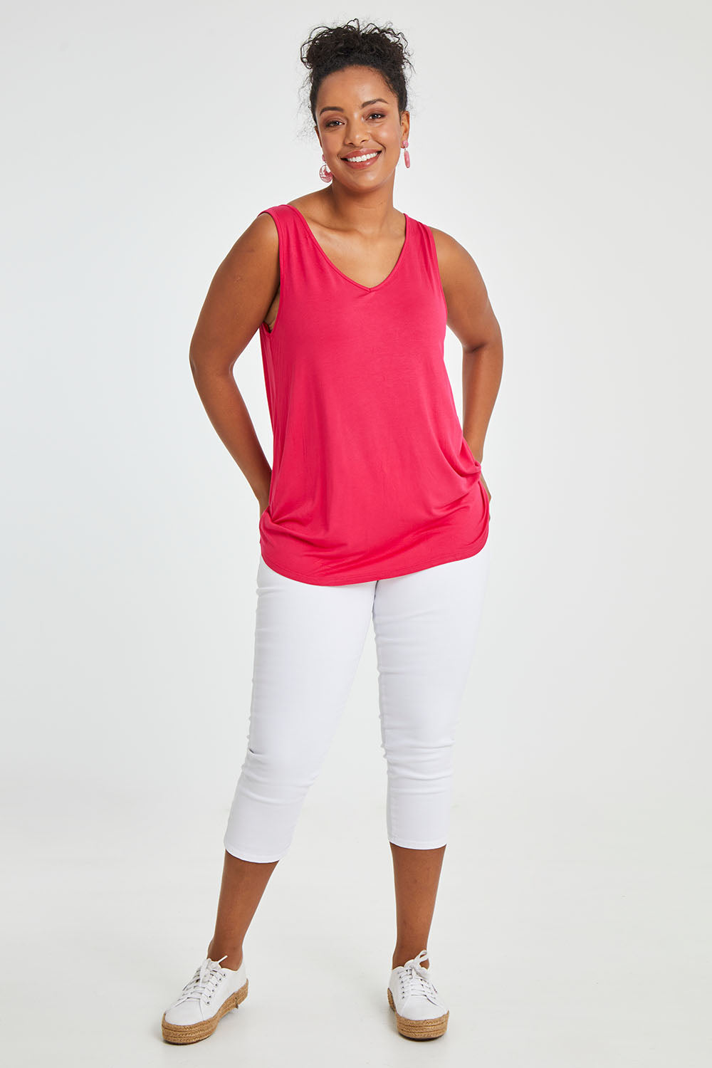 Model Noli wearing size 14 of the Sirena Reversible Tank in colour Rosered (Red), from the front, showing the whole outfit