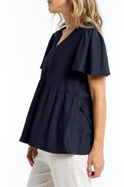A model wearing the Abigail Blouse in colour Nigshadow (Blue), from the front, cropped image