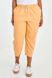 Model Noli wearing size 10 of the Lennon Pant in colour Mango, from the front, cropped image