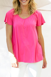 A model wearing the Coral Bamboo Shirred Tee in colour Pink (Pink), from the front, cropped image