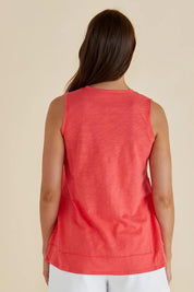 A model wearing the Mariah Cotton Tank in colour Grapefruit (Pink), from the back