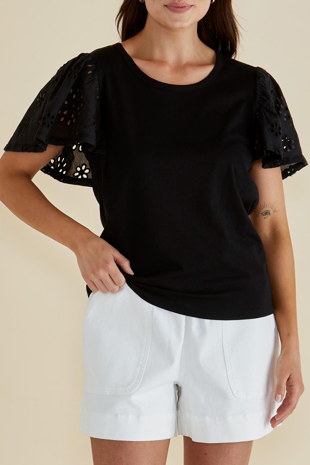 A model wearing the Lottie Embroidered Cotton Tee in colour Black (Black), from the front, cropped image