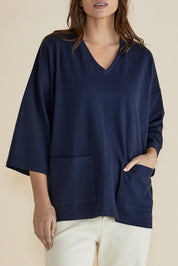 A model wearing the Raven Cotton Top in colour Navy (Blue), from the front, cropped image