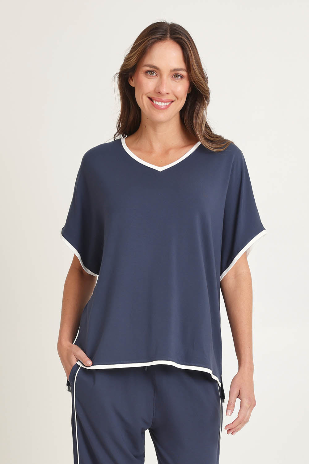 Model Madeline wearing size 10 of the Clara Tee in colour Petrol (Blue), from the front, cropped image