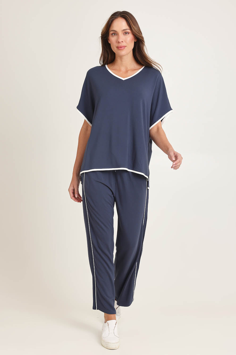 Model Madeline wearing size 10 of the Clara Tee in colour Petrol (Blue), from the front, showing the whole outfit