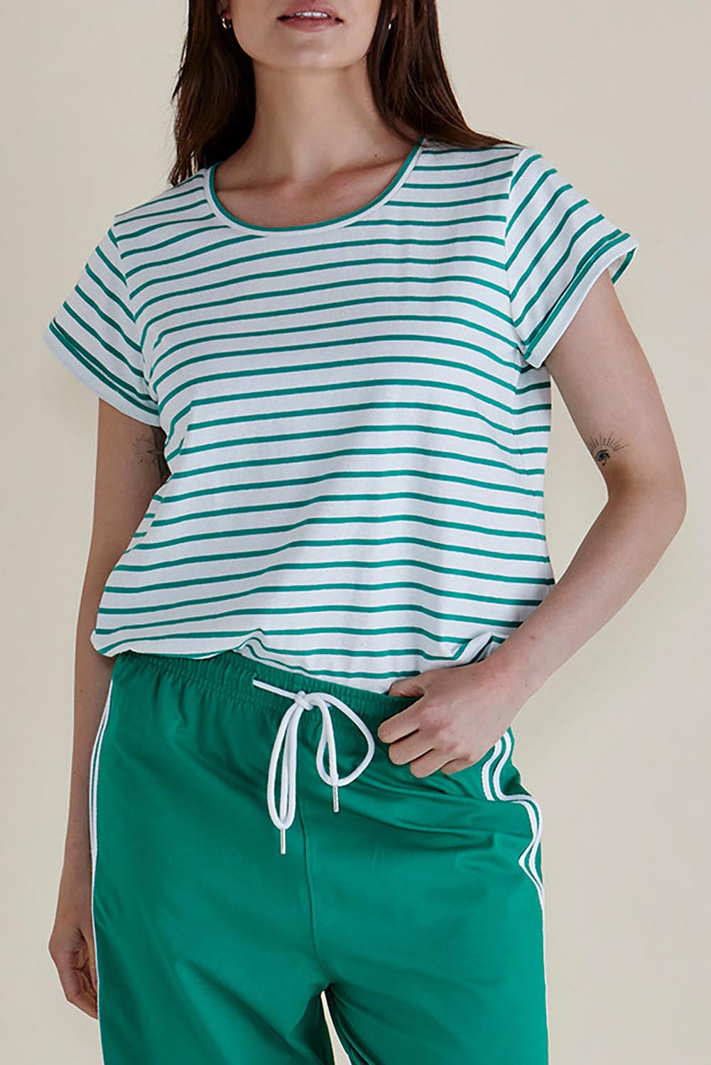 A model wearing the Caia Cotton Crew Tee in colour Grnstripe (Green), from the front, cropped image