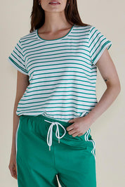 A model wearing the Caia Cotton Crew Tee in colour Grnstripe (Green), from the front, cropped image