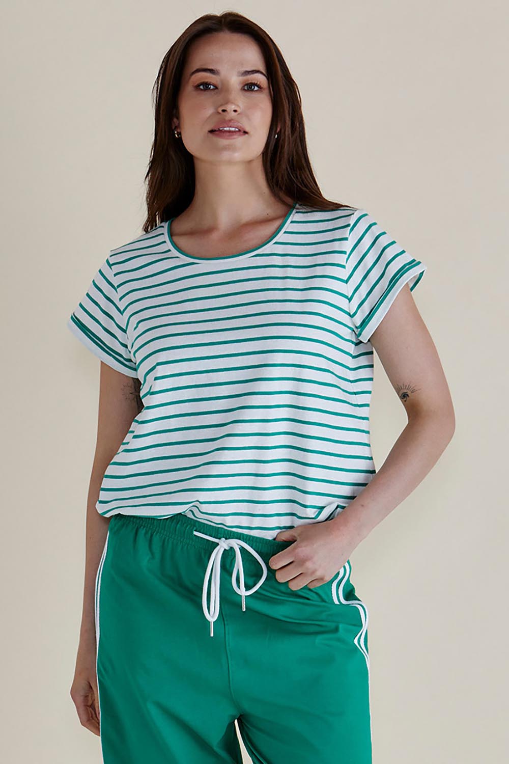 A model wearing the Caia Cotton Crew Tee in colour Grnstripe (Green), from the front, cropped image