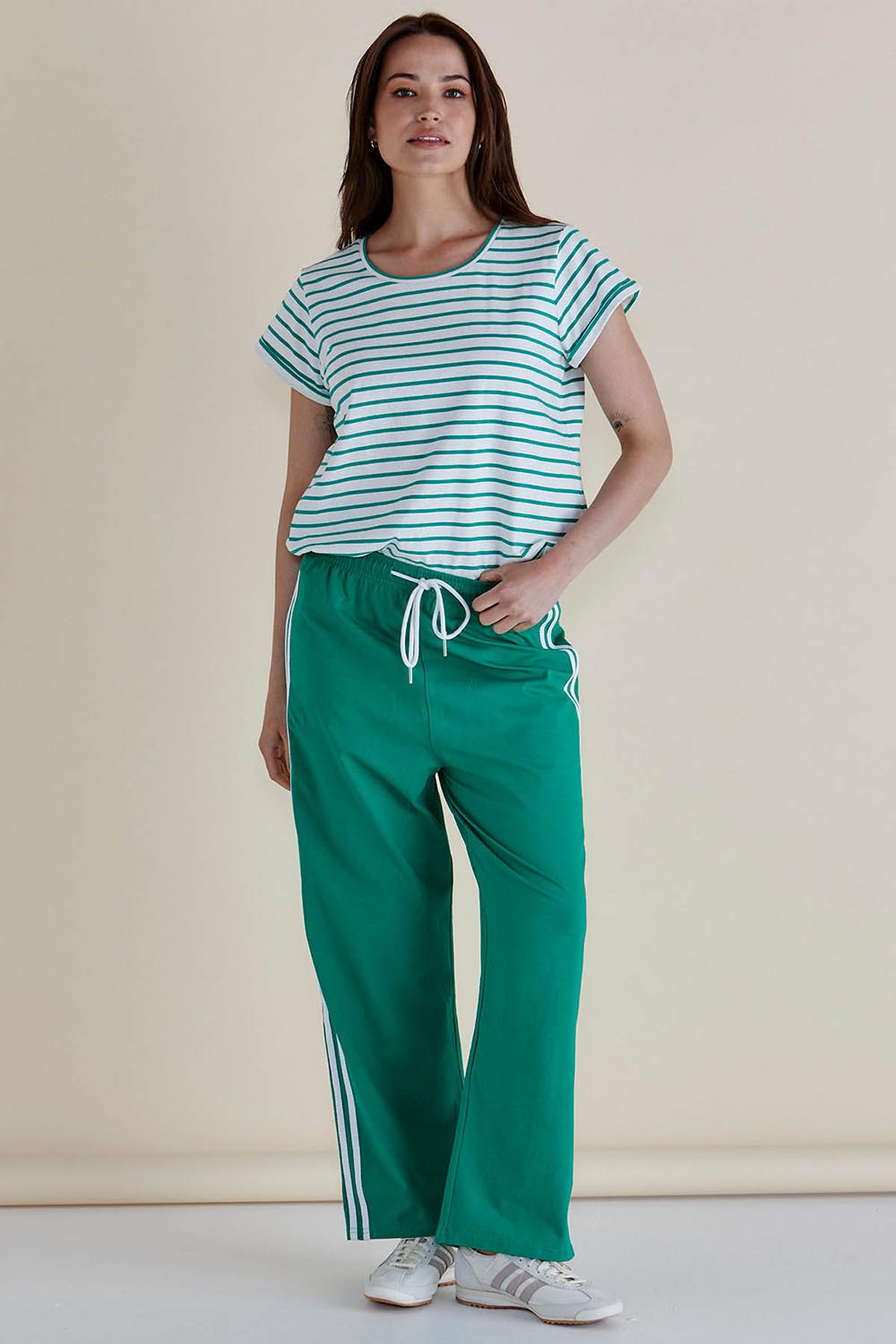 A model wearing the Caia Cotton Crew Tee in colour Grnstripe (Green), from the front, showing the whole outfit
