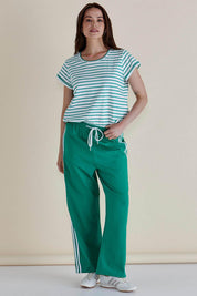 A model wearing the Caia Cotton Crew Tee in colour Grnstripe (Green), from the front, showing the whole outfit