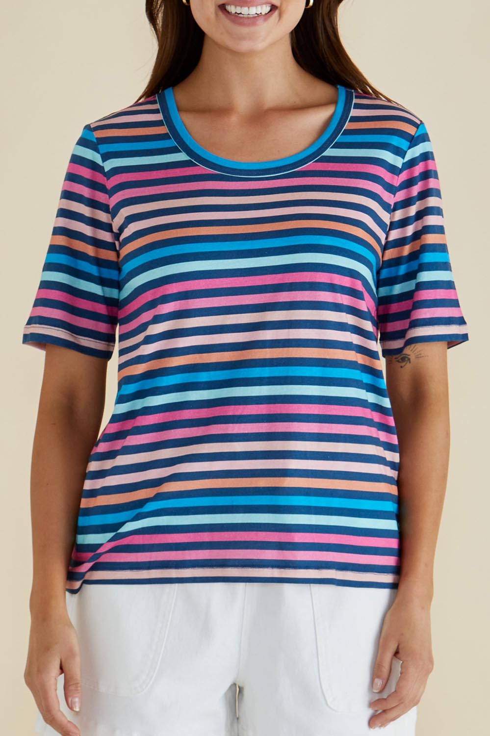 A model wearing the Riley Cotton Tee in colour Multistrip, from the front, cropped image