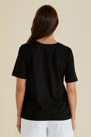 A model wearing the Riley Cotton Tee in colour Black (Black), from the back