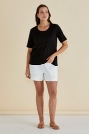 A model wearing the Riley Cotton Tee in colour Black (Black), from the front, showing the whole outfit