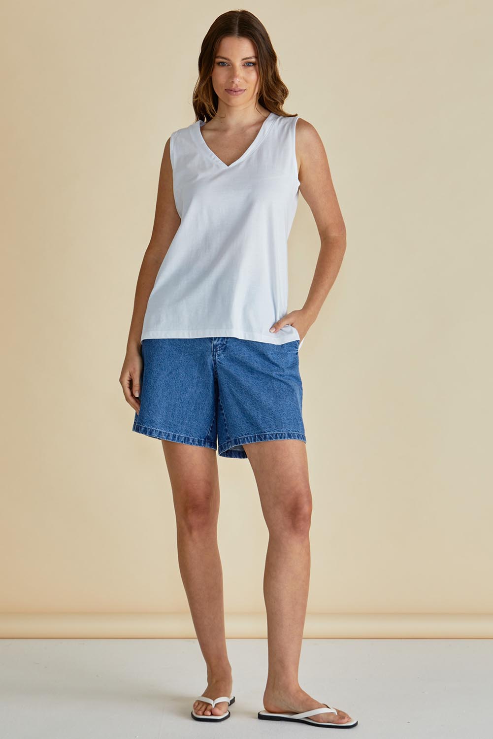A model wearing the Trinity Vin colourNeck Cotton Tank - White (White), from the front, showing the whole outfit