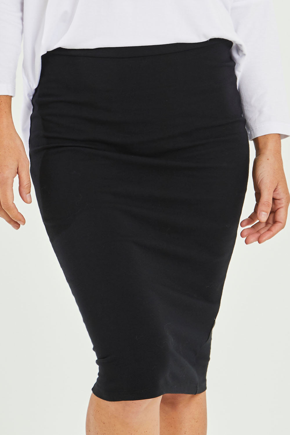 Model Katie wearing size 10 of the Alicia Midi Skirt in colour Black (Black), from the front, cropped image