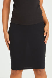 Model Olivia wearing size 10 of the Alicia Midi Skirt in colour Black (Black), from the front, cropped image