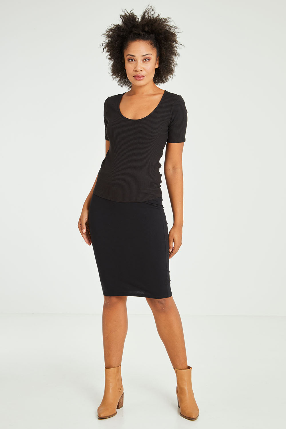 Model Olivia wearing size 10 of the Alicia Midi Skirt in colour Black (Black), from the front, showing the whole outfit