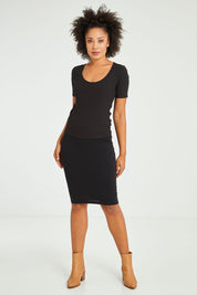 Model Olivia wearing size 10 of the Alicia Midi Skirt in colour Black (Black), from the front, showing the whole outfit