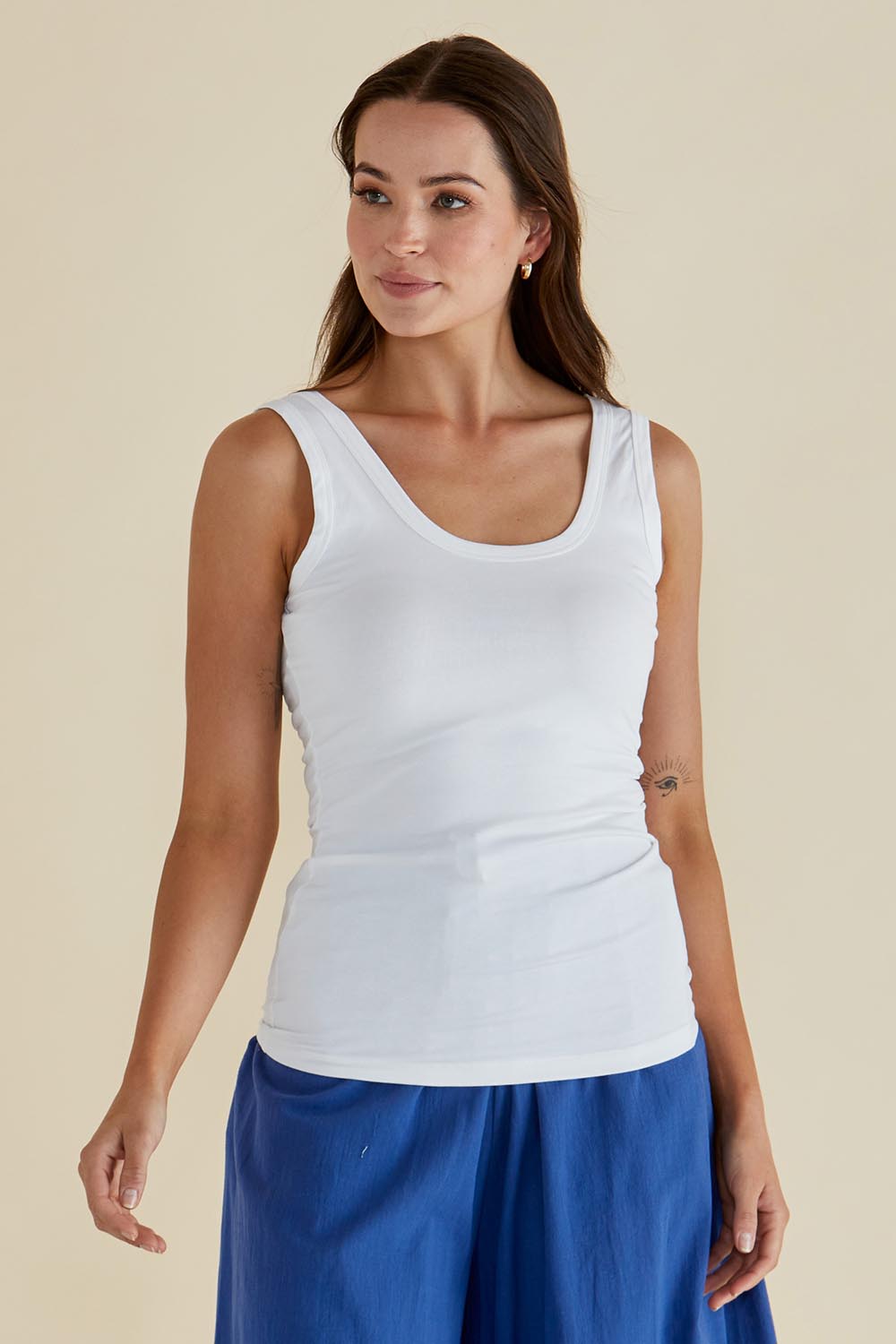 A model wearing the Emma Cotton Scoop Tank in colour White (White), from the front, cropped image
