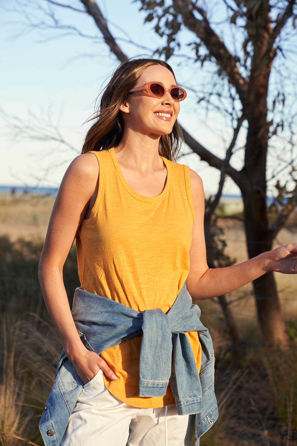 A model wearing the Keira Tank in colour Mustard, from the front, showing the whole outfit