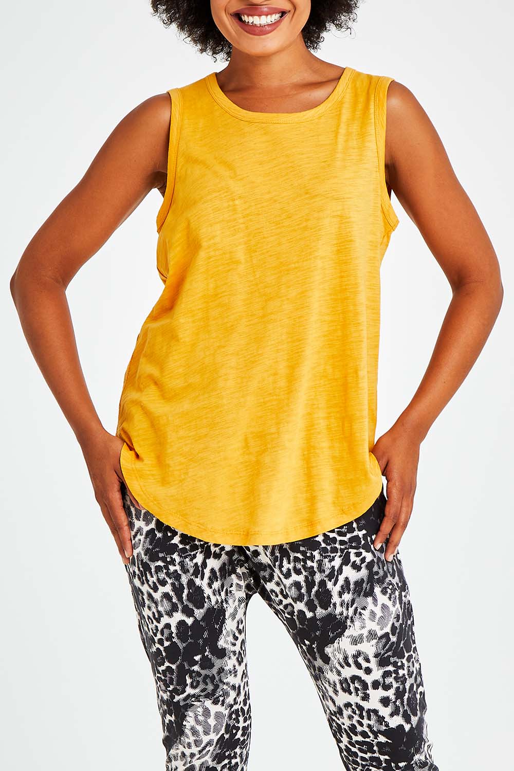 Model Olivia wearing size 10 of the Keira Tank in colour Mustard, from the front, cropped image