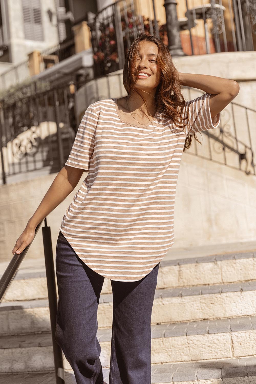 A model wearing the Ariana Cotton Tee in colour Beigestrip, from the front, showing the whole outfit