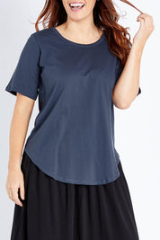 Model Laura wearing size 12 of the Ariana Tee in colour Indiblue (Blue), from the front, cropped image