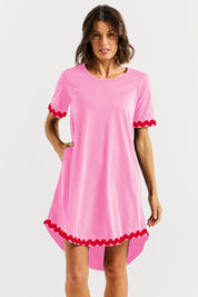 A model wearing the Nyree Cotton Dress in colour Redpinkric (Pink), from the front, cropped image